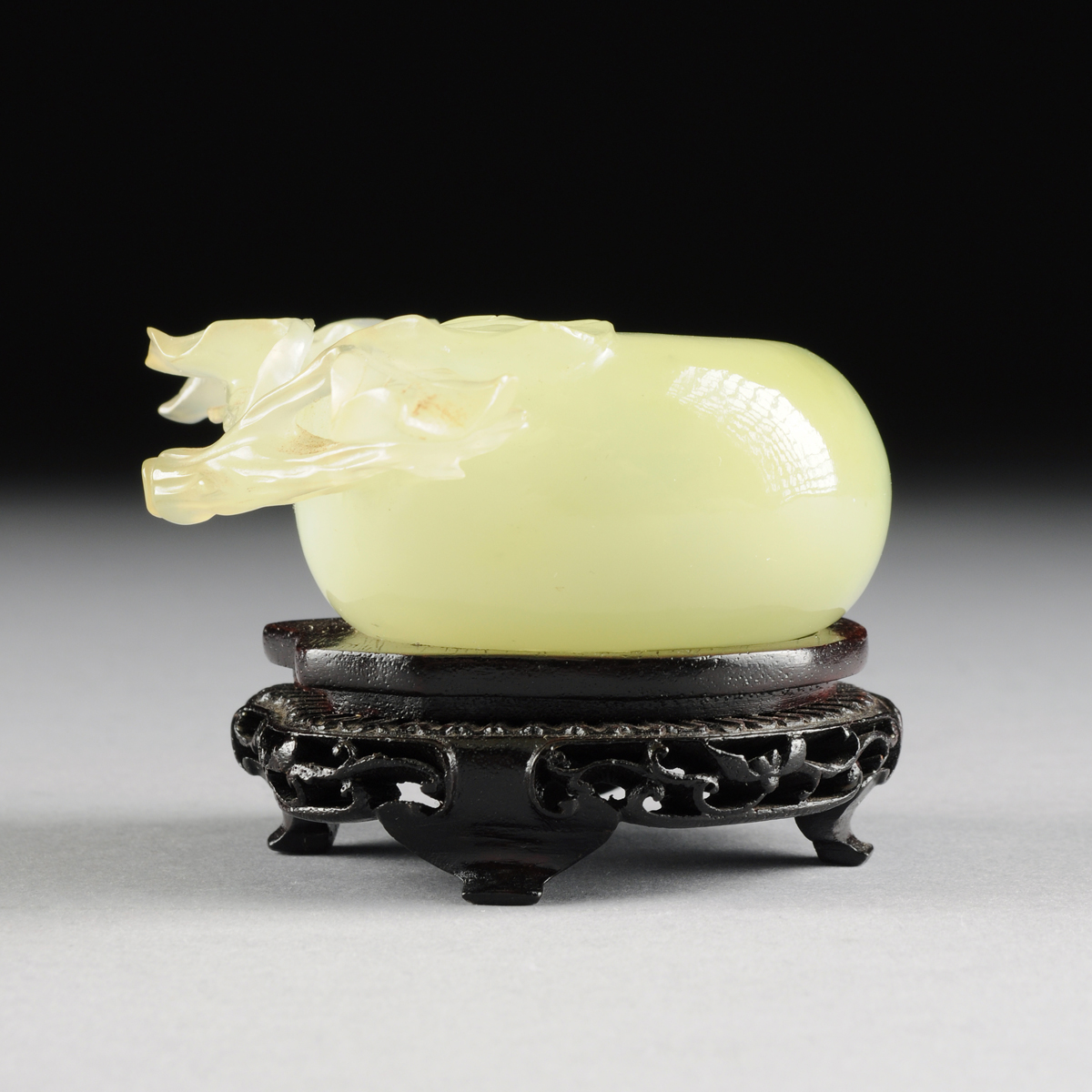 A CHINESE CARVED JADEITE BRUSH WASHER, 20TH CENTURY, in the form of a peach with leaves, of pale