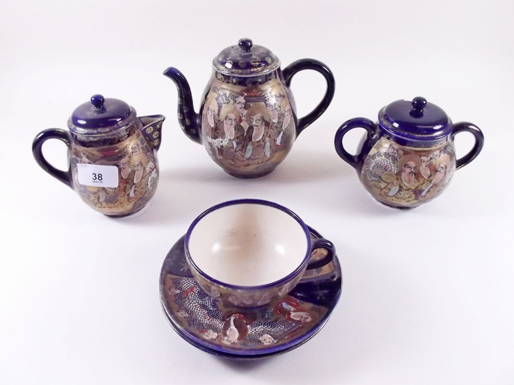 A Japanese satsuma teaset comprising: teapot, hot water jug, sugar, three cups and six saucers