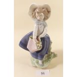 A Lladro figure - girl with basket of flowers