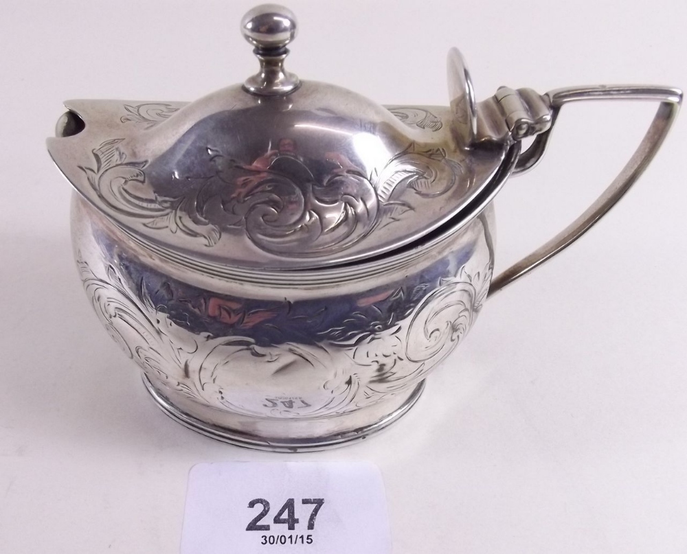 A Georgian silver oval mustard pot with engraved decoration and hinged lid, missing liner - London