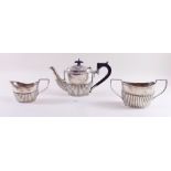 A silver half reeded teapot - 12ozs - Chester 1907 by Barker Bros and a matching milk and sugar -