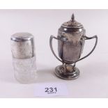 A silver three handled caster and a cut glass and silver smelling salts bottle