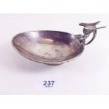 A silver cigar stand/ashtray - the handle in the form of a dragon - its wings forming the cigar rest