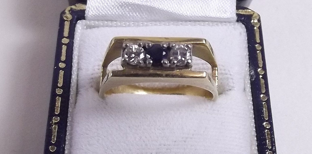 An 18 carat gold ring set sapphire and two diamonds