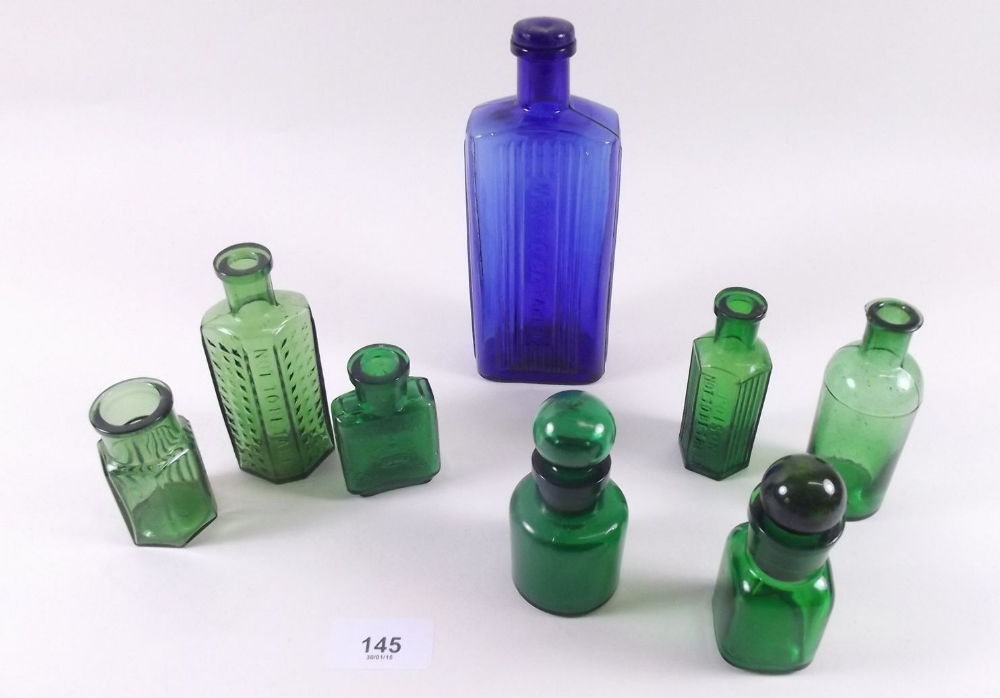 A group of seven green small bottles and one blue