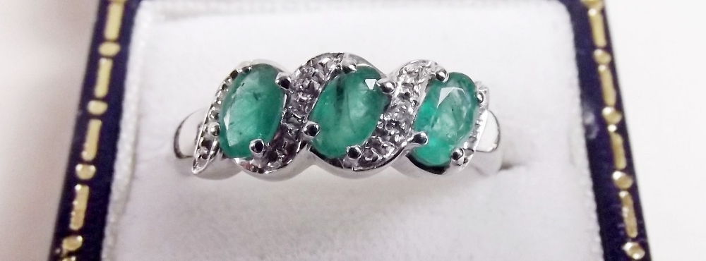 A silver three stone emerald ring
