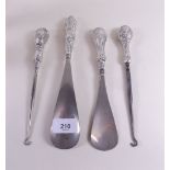 Two silver handled shoe horns and two button hooks