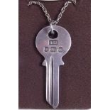 A silver hallmarked pendant in the shape of a Yale key