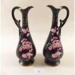 A pair of Edwardian ewers painted blossom on a black ground by Imperial Windsor Ware