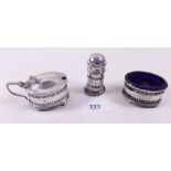 A three piece silver cruet set with blue glass liners