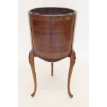 An Edwardian mahogany circular jardiniere stand on slender leaf carved supports