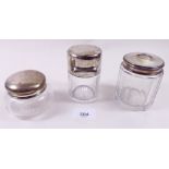 Three silver topped toiletry bottles