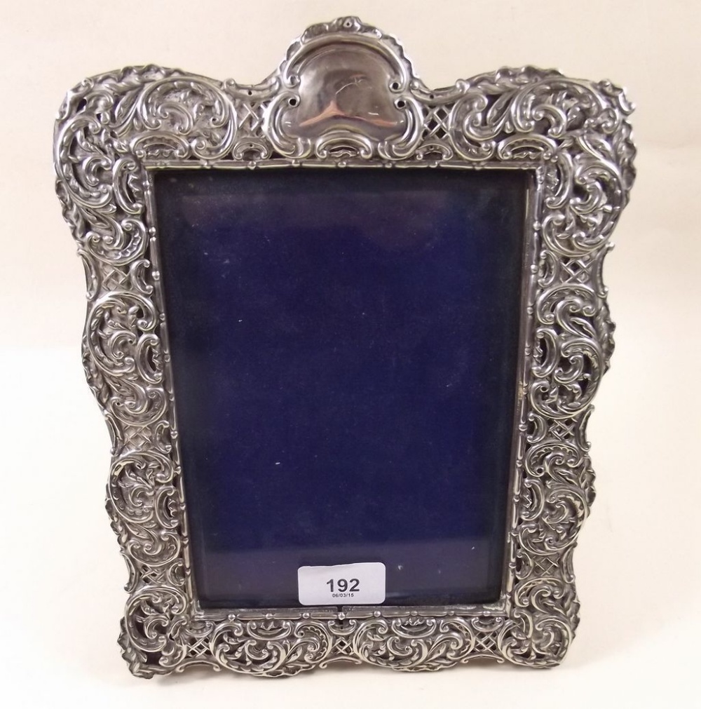 An Edwardian silver photograph frame with all over embossed decoration - 27 x 20cm
