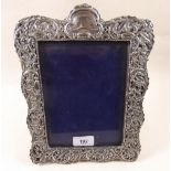 An Edwardian silver photograph frame with all over embossed decoration - 27 x 20cm