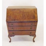 A 1930's walnut bureau with three drawers on cabriole supports