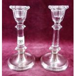 A pair of cut glass and silver mounted candlesticks