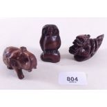 Three wood netsukes including dragon, elephant and an owl
