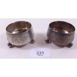 A pair of Victorian silver circular salts with engraved decoration - London 1884