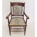 A 1930's oak carver chair with tapestry upholstered seat and back