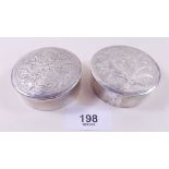 A pair of white metal circular boxes engraved flowers