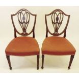 A pair of Edwardian mahogany shield back dining chairs with satinwood inlay