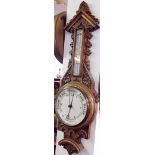 A Victorian carved oak aneroid barometer