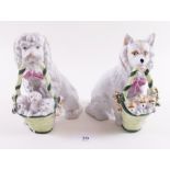 Two continental porcelain dogs carrying puppies in baskets