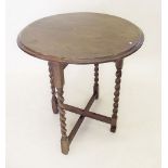 An oak circular folding occasional table