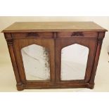 A Regency rosewood side cabinet with two frieze drawers over two mirrored arch top doors flanked