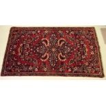 A Persian village rug with red ground 196 x 109cm