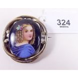 A Victorian painted porcelain brooch depicting young girl in pinchbeck surround
