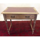 An Edwardian satin walnut table with leather top, turned supports and frieze drawer