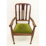 An oak Arts and Crafts open armchair with floral carved decoration