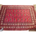 A Persian carpet with geometric motifs on a red ground 290 x 208cm