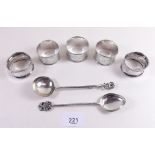 A group of five silver napkin rings and a pair of white metal spoons