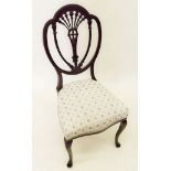 An upholstered ebony salon chair on cabriole supports with carved shield back
