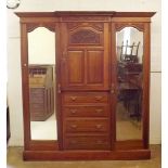 A Victorian Beaconsfield wardrobe with two mirror doors flanking cupboard and drawers, all with