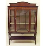 An Edwardian mahogany inlaid display cabinet with single door all over under tier