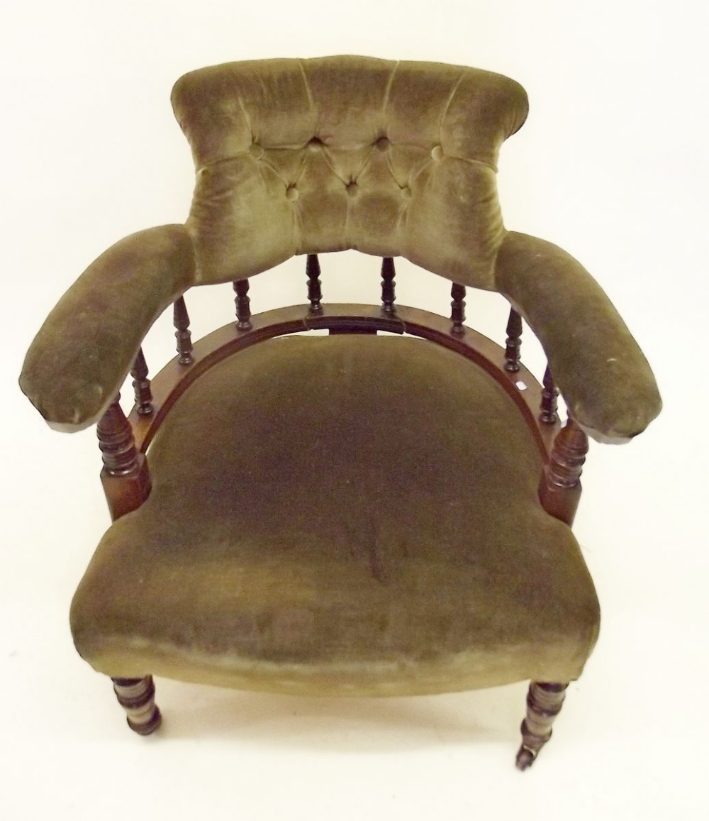 A Victorian tub chair with button upholstered and spindle back