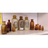 Three stoneware bottles with printed labels and ten brown glass bottles