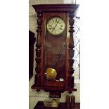 A large Victorian mahogany Vienna style wall clock with carved pilasters flanking glazed door
