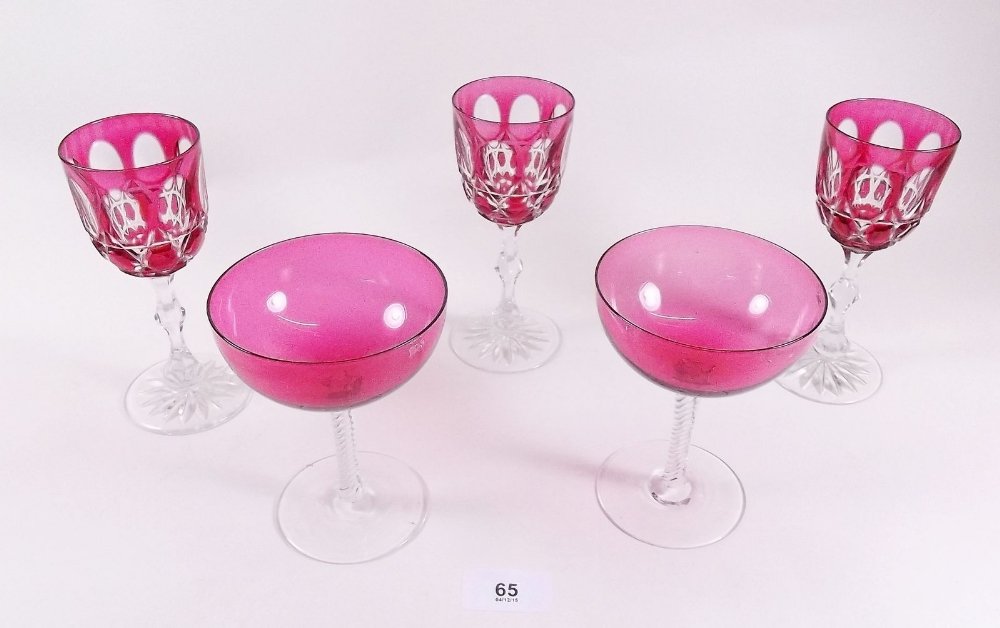 Two cranberry champagne glasses and three cranberry cut glass wine glasses