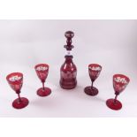 A Bohemian red flashed liquor decanter and four glasses etched vines