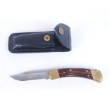 Buck 110, lock blade knife with 3,3/4 ins clip point blade, brass mounts, rosewood grips, leather