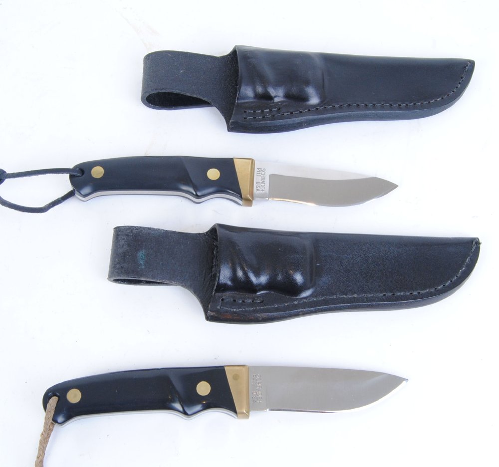 Two Schrade PH 1, knives with 3,1/2 ins single edge blades, brass mounts and studs, composite