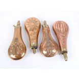 Four various copper and brass powder flasks with embossed fluted, starburst and other decorations