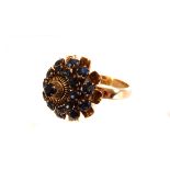 An 18ct gold and sapphire cluster dress ring, the graduated blue round cut sapphires in claw mounts,