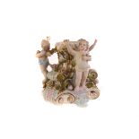 A Sitzendorf ceramic pedestal, with three applied cherubs holding flowers, amongst roses, on