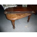 A mahogany Victorian extending dining table, the top with moulded rounded corners, opens on