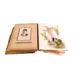 A vintage photograph album, containing various black and white portrait photographs, mainly family